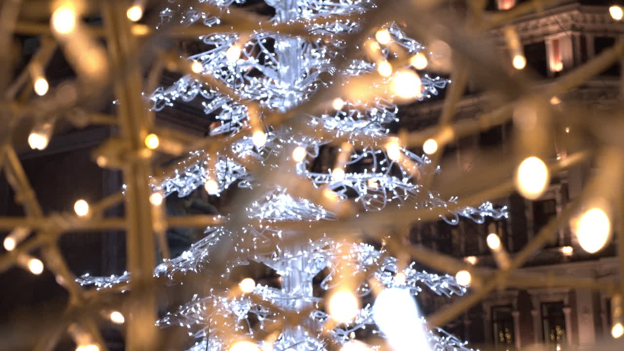 brillante decoración del árbol de navidad en el centro de la ciudad con luces festivas en primer plano