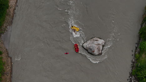 drone shot tourists rafting flooded bhotekoshi river monsoon in nepal, adventurous and life-risking experience navigating around huge rock and dealing powerful currents, thrilling dangerous tourism