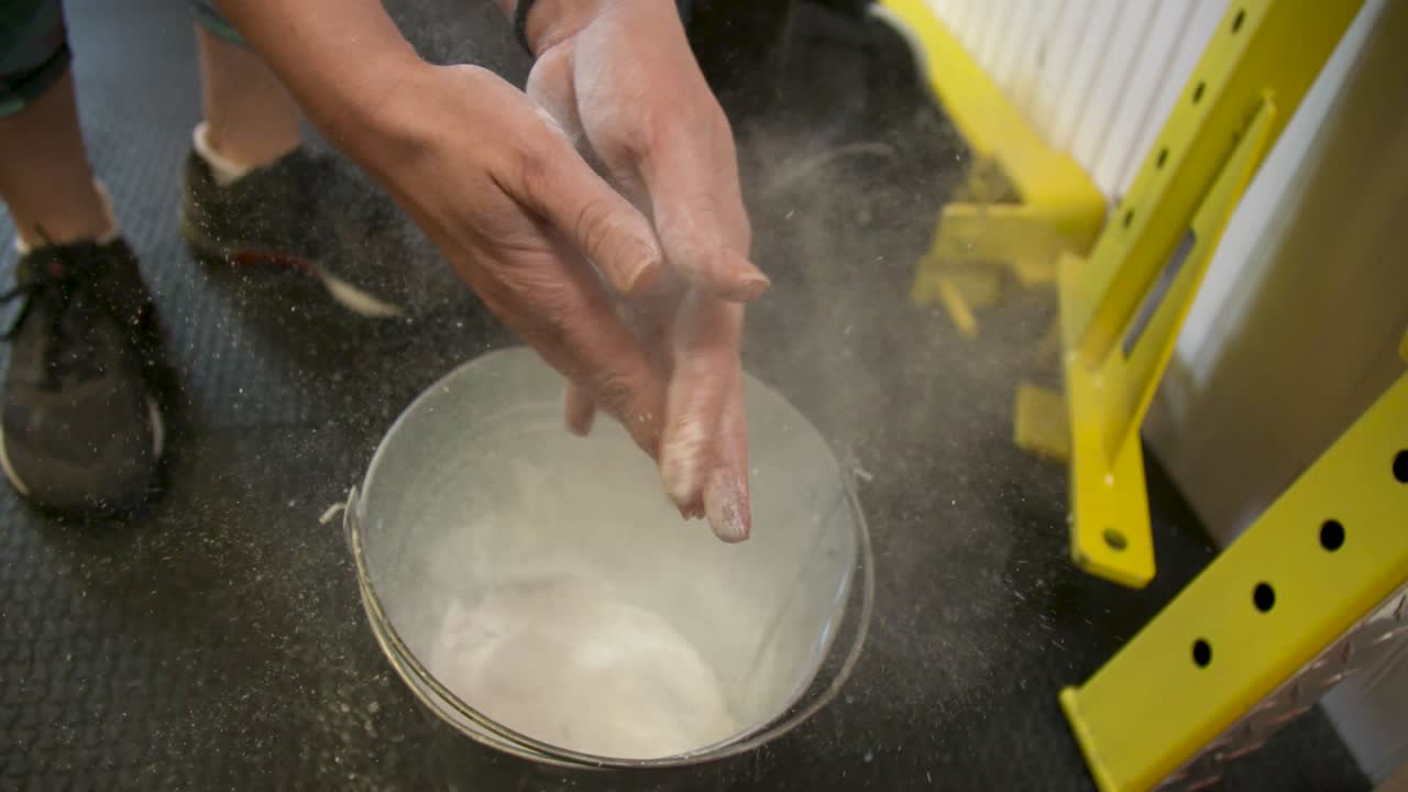woman claps her hand with powder at gym