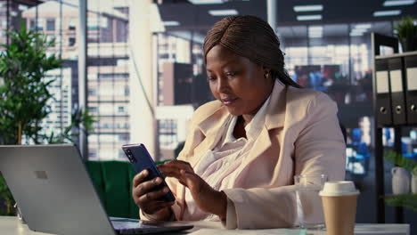 businesswoman working on laptop and phone in modern office