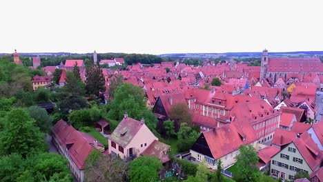 a drone rises above a park full of greenery with a view of the old town