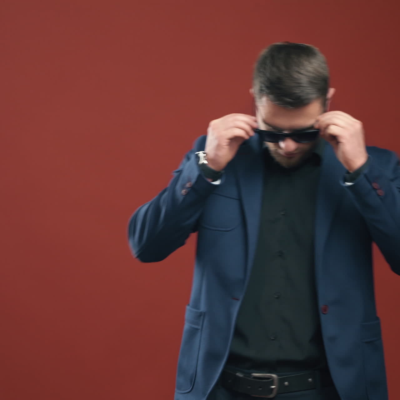 Side view of entrepreneur in glasses. Handsome bearded man in stylish costume isolated in studio. Young businessman in black glasses indoors.
