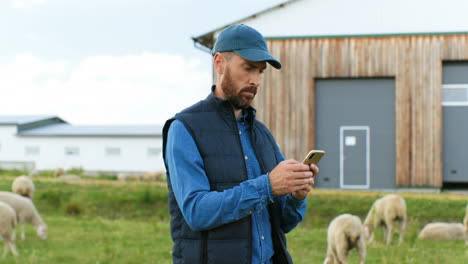 hombre agricultor caucásico enviando mensajes de texto en el teléfono inteligente afuera