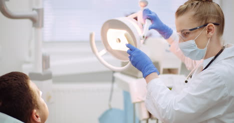 mujer dentista trata al paciente en la clínica dental