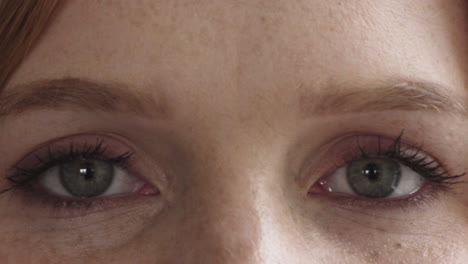 cerca de los ojos de la mujer parpadeando mirando a la cámara de la cara pecas