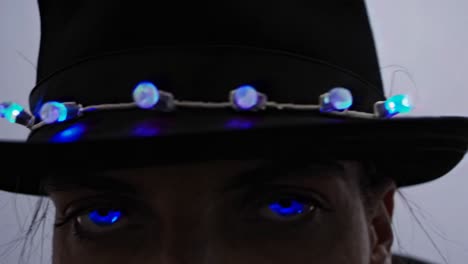 woman with blue glowing eyes and led hat