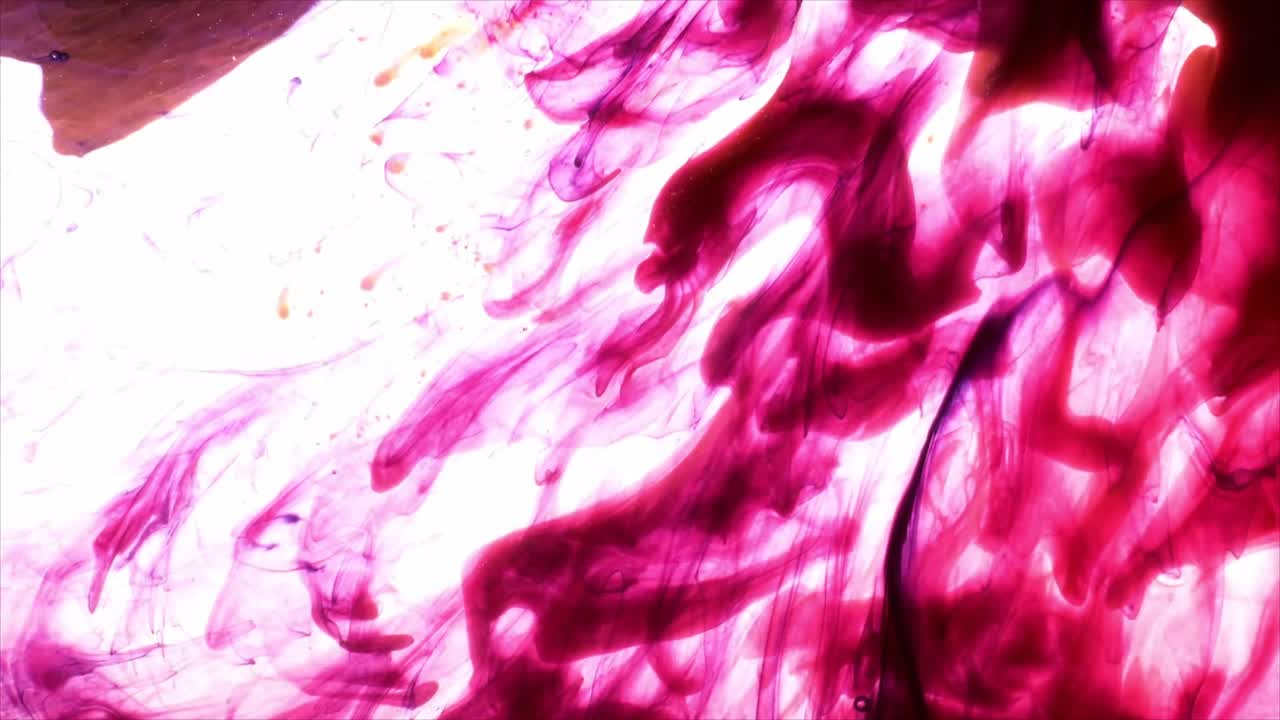 Encre rose et violette tourbillonnant dans l'eau sur fond blanc