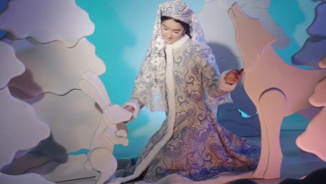 lovely girl snow maiden is stroking a fairy wild animals in tale forest