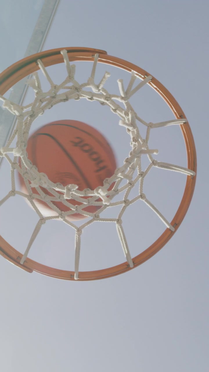 Pallone da Basket che Attraversa il Canestro Durante una Partita