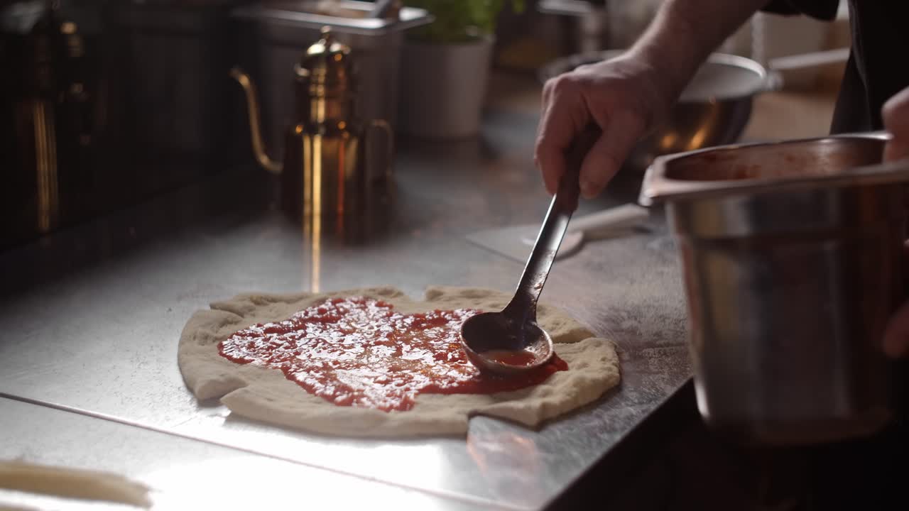 Il cuoco che prepara la pizza.