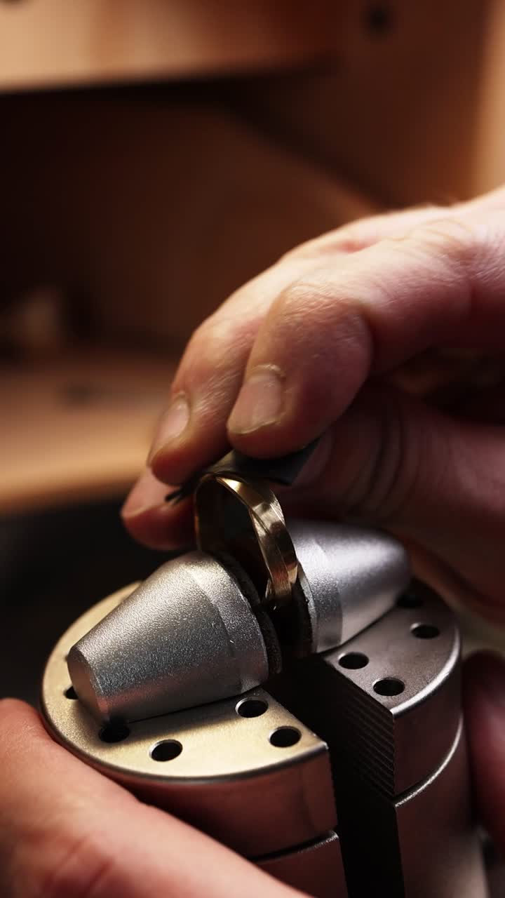 Close-up of Jeweler's Hand Polishing a Gold Ring in a Workshop