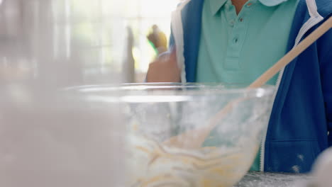 niño feliz comiendo restos de masa de galletas en la cocina disfrutando del delicioso sabor dulce lamiendo los dedos divirtiéndose el fin de semana