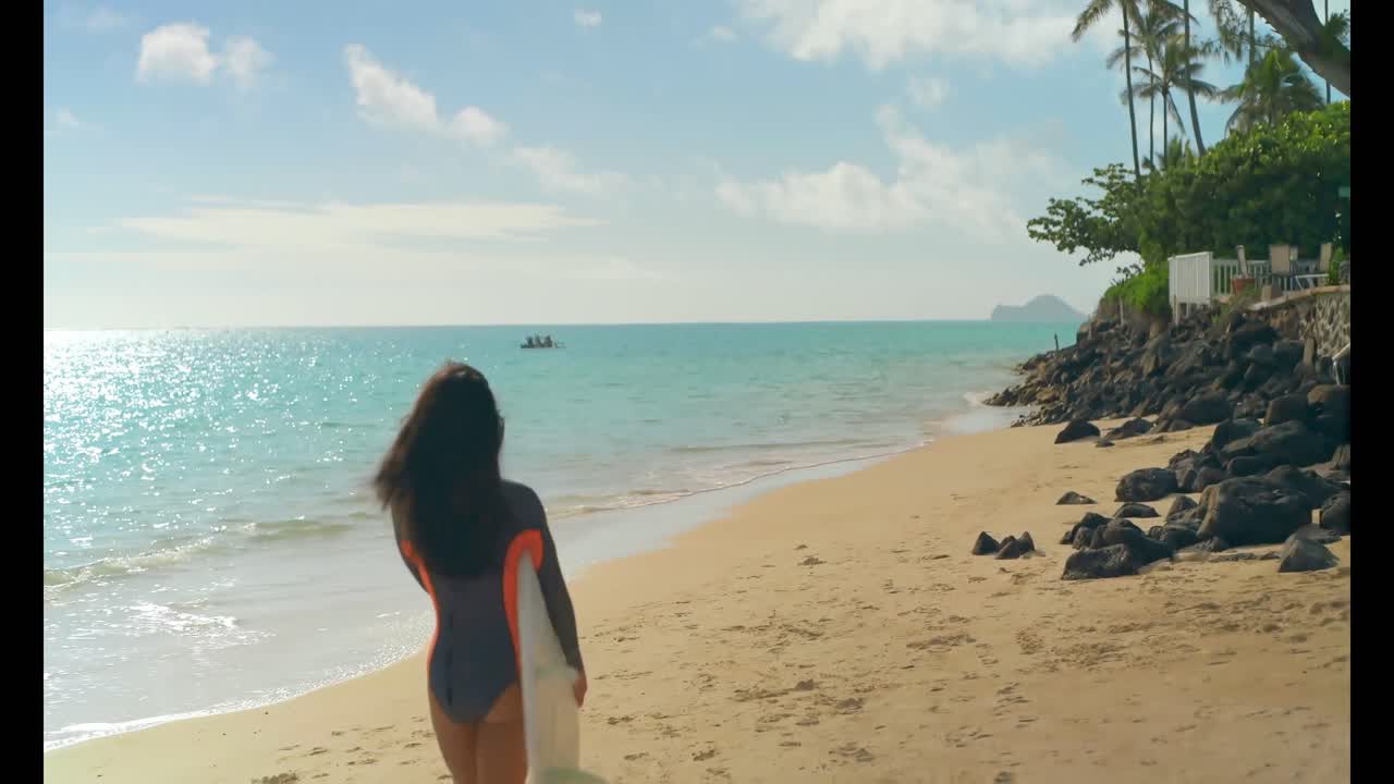 해변 4k에서 서프보드와 함께  ⁇ 고 있는 여성 서퍼