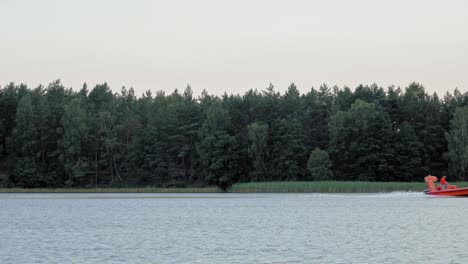 Orange-Motorboat-Cruising-By-The-Beautiful-Lake-In-Wdzydze-Landscape-Park-In-Poland---Wide-Shot