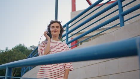 un adolescente caminando disfruta de la música con auriculares sosteniendo un reproductor de cassette portátil.