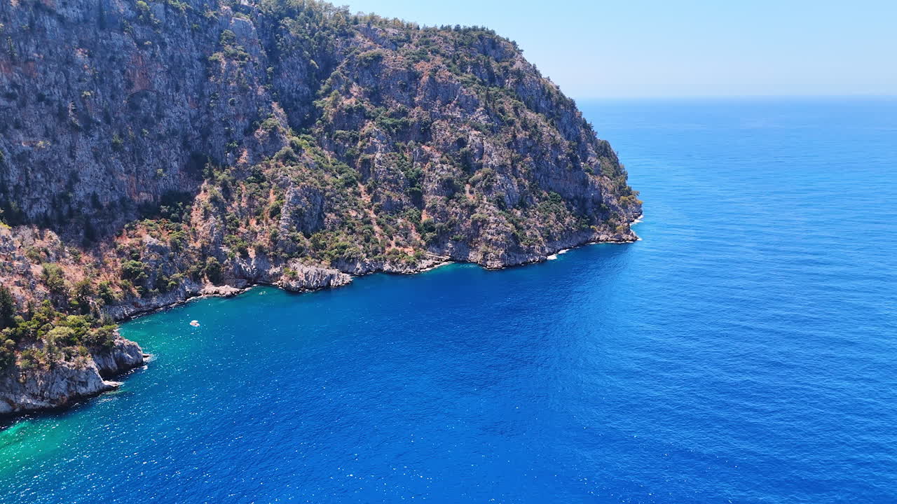 Gorgeous coast, clear blue water. Breathtaking view of cliffs embracing the turquoise sea on a sunny day along the coastline