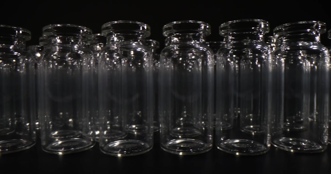 Small glass jars stand neatly arranged on laboratory table