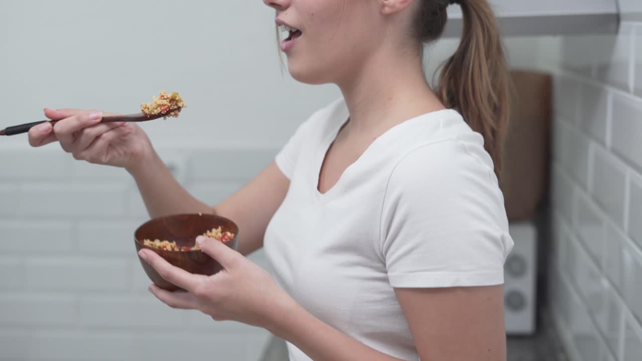 Woman eating healthy food in the kitchen