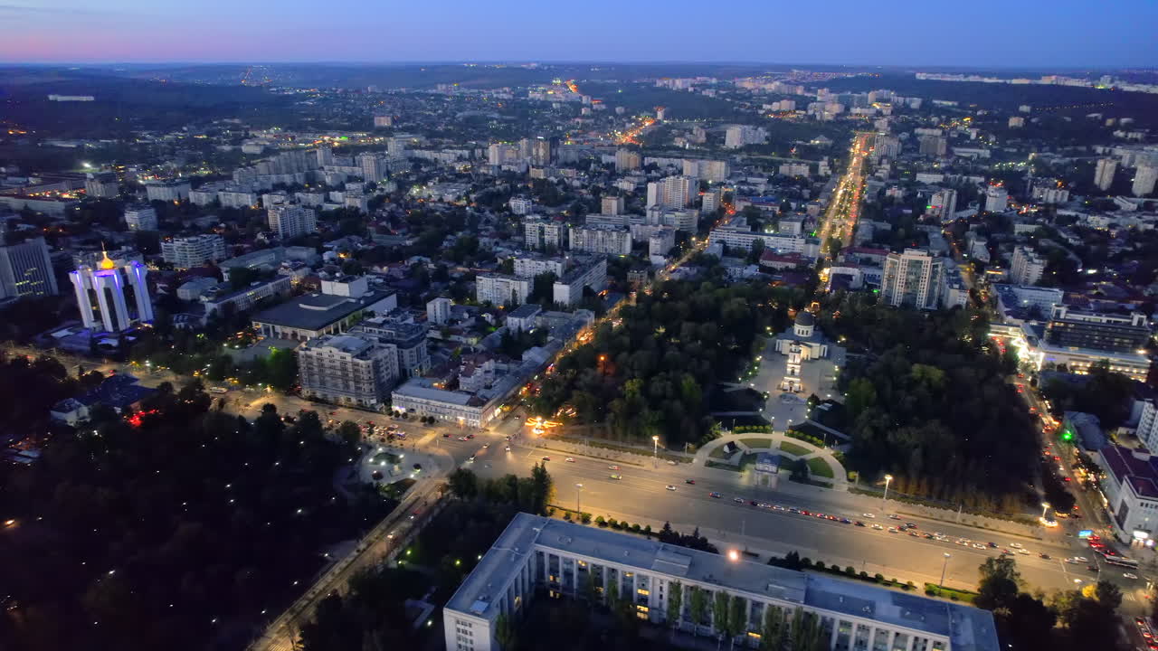 Aerial drone view of Chisinau downtown at evening, Moldova. View of central parks, Cathedral, Goverment and a lot of greenery, buildings, illumination