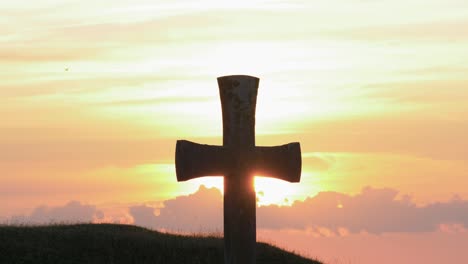 silhouette of a cross against a dramatic sky