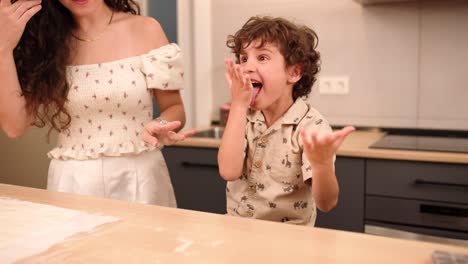 Mother and son having fun cooking in kitchen at home