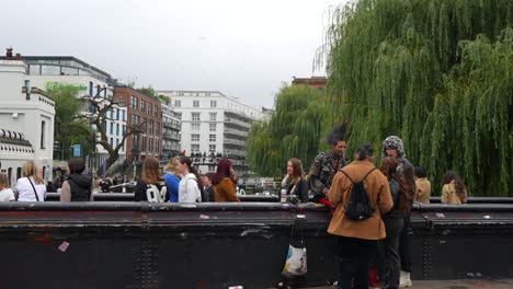people on a bridge over a canal in a city
