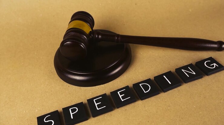 Concetto legale che illustra una violazione del codice della strada per eccesso di velocità con tessere di lettere e un martelletto da giudice in legno su uno sfondo marrone, a simboleggiare il tribunale per le infrazioni stradali, la legge e la giustizia per la guida spericolata.