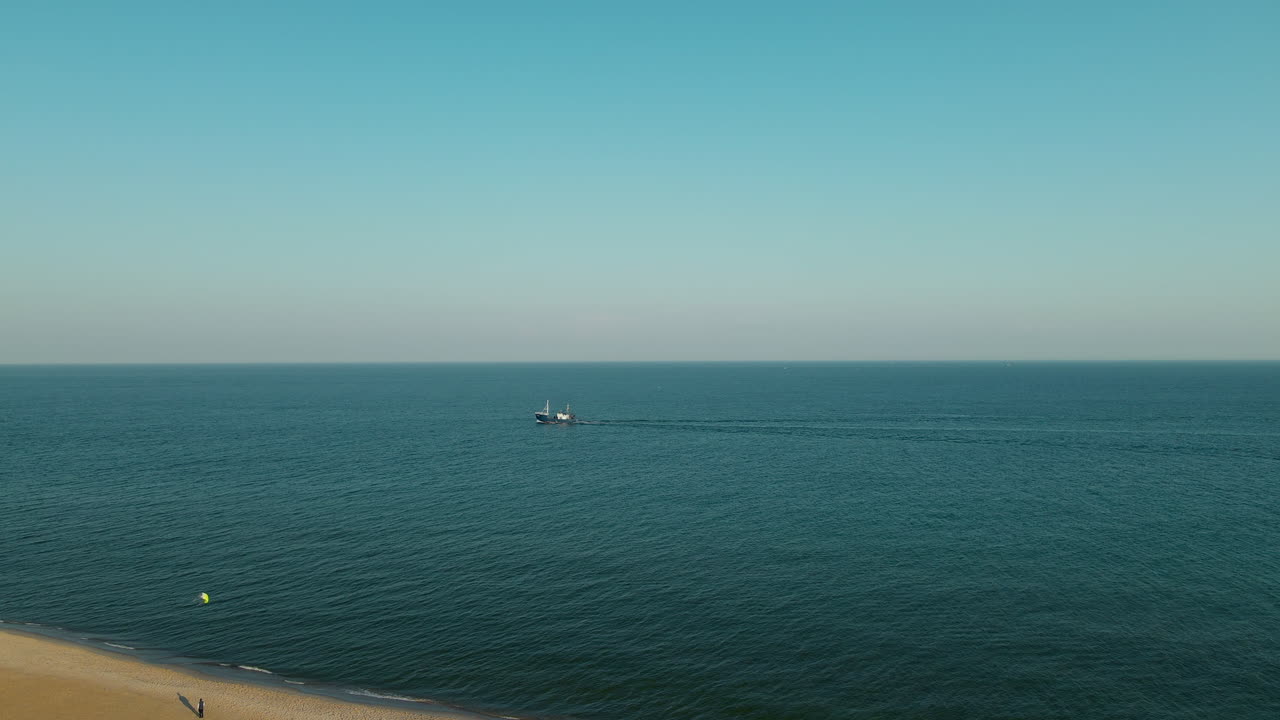 푸른 발트해에서 순항하는 보트와 폴란드 헬의 황금 해변에서 연을 날리는 사람들의 공중 와이드 샷