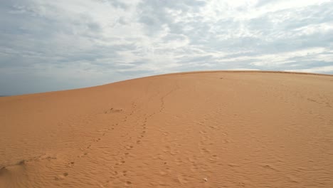 vuelo aéreo bajo sobre la cima de una duna de arena del desierto en mui ne vietnam