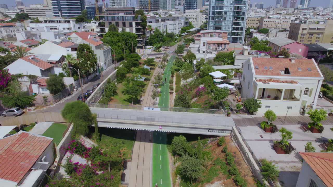 HaMesila Park på en meget varm dag med få mennesker og cyklister i Neve Tzedek-kvarteret, Tel Aviv