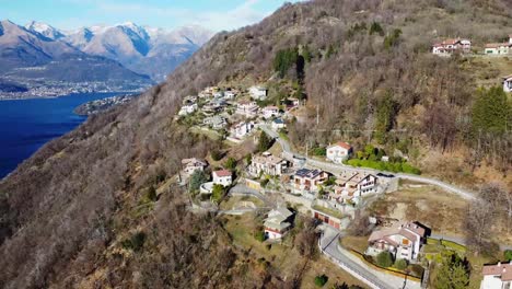 cozy mountain village and lake como in background, aerial view