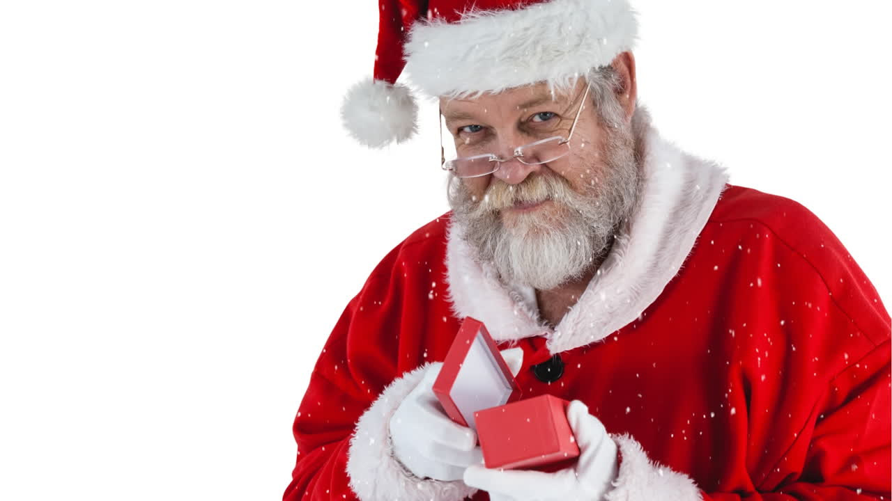 Animazione di neve che cade su Babbo Natale caucasico che tiene in mano un regalo