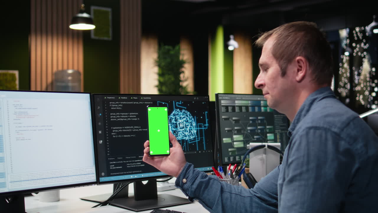 Man Holding Smartphone with Green Screen While Working in Office