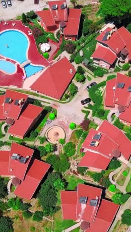 aerial view of a luxurious residential complex with swimming pools and red roofs