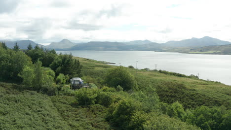 Luftanflug-–-Ein-Modernes-Hüttenhaus-Aus-Aluminium-Im-Sommer-In-Schottland