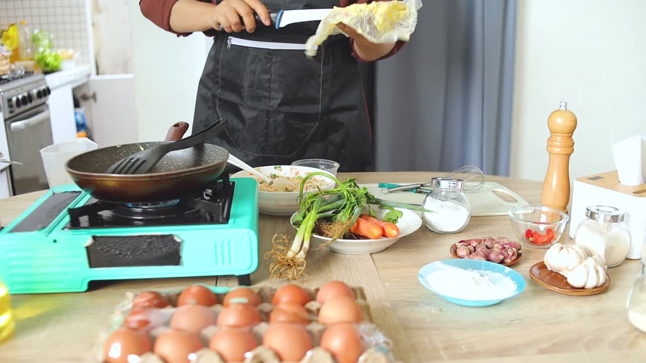 Koki menyiapkan adonan segar untuk Bala-Bala (bakwan sayuran Indonesia) di pengaturan dapur modern.