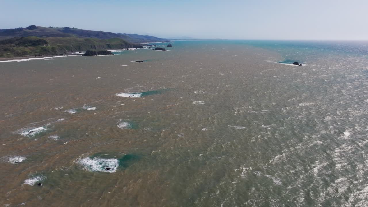 tomada aérea de drones de agua marrón y sucia mezclándose con el agua del océano frente a la costa del pacífico