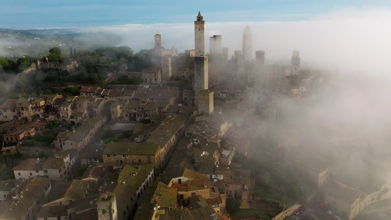 ciudad de san gimignano en una mañana brumosa en toscana, italia - retroceso aéreo