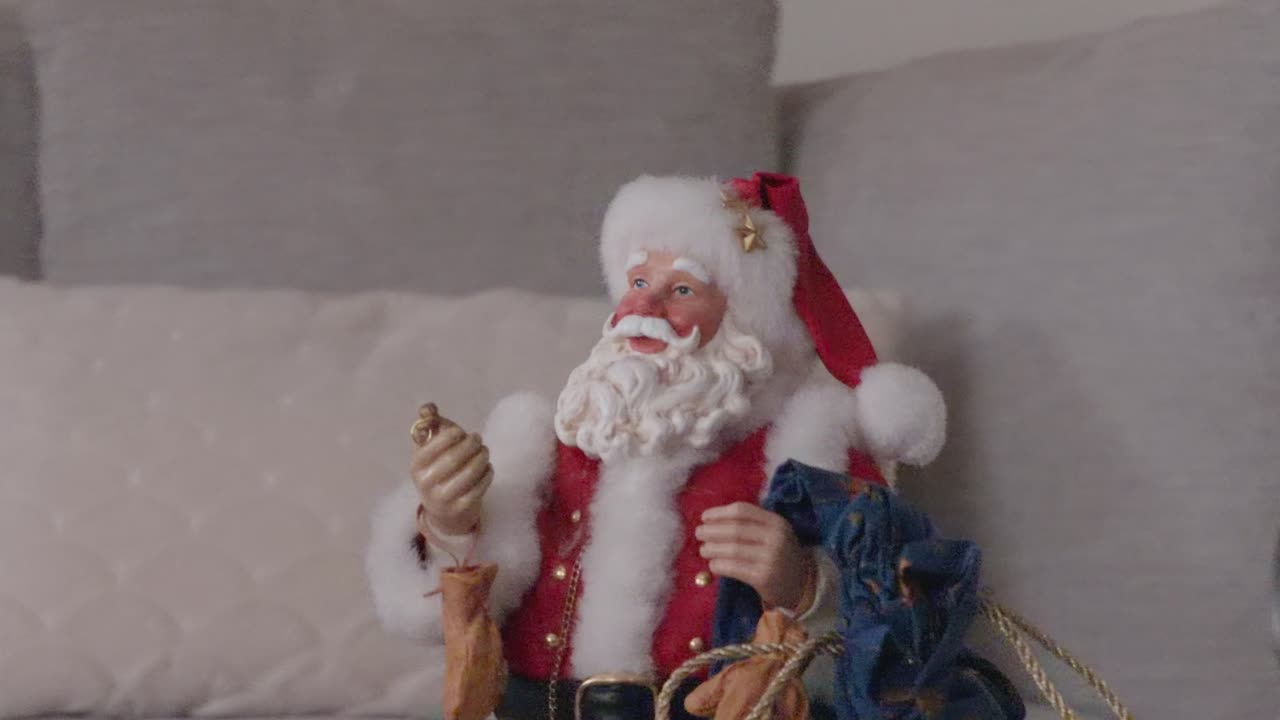 Panoramica al rallentatore e rotazione delicata di un addobbo di Babbo Natale esposto su un divano