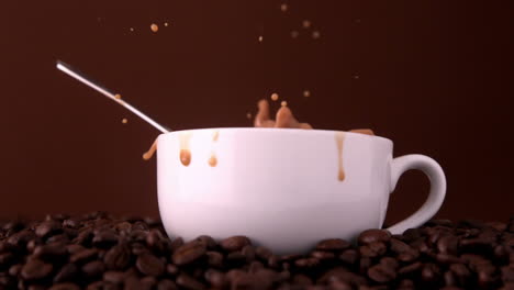 teaspoon falling into white coffee cup