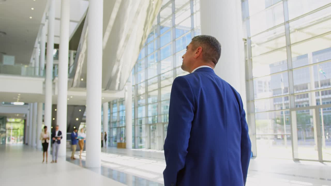 uomo d'affari caucasico che cammina nella hall dell'ufficio 4k