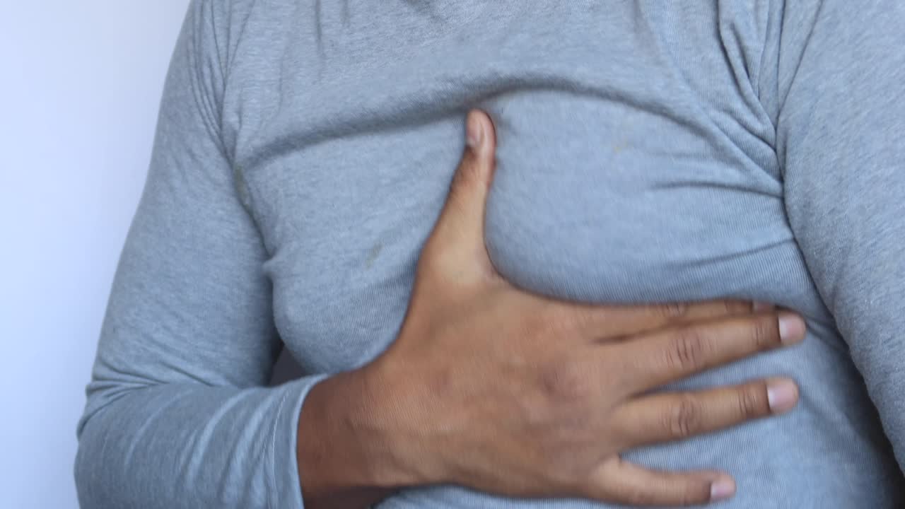 hombre sosteniendo su pecho en dolor