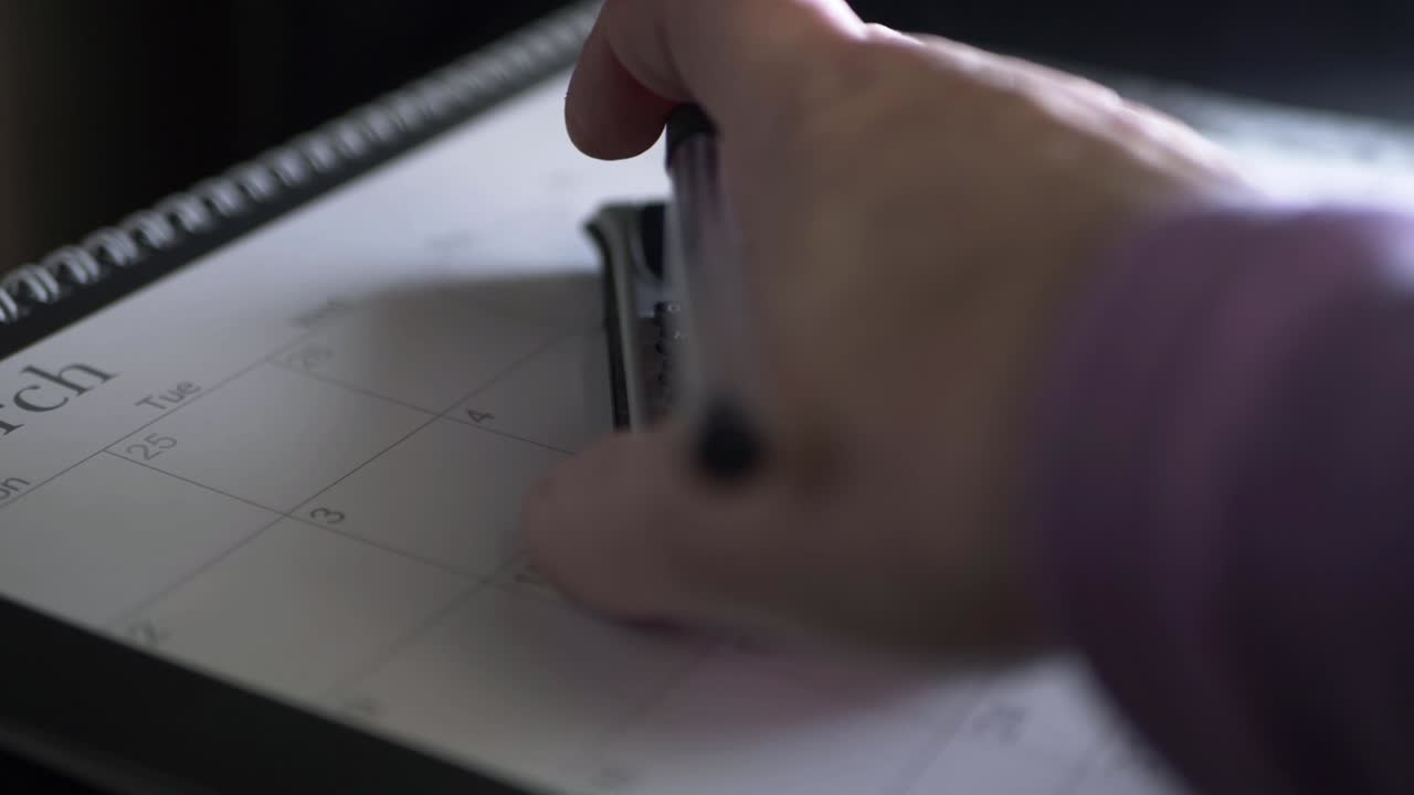 Hand with pen using calculator in January close up panning shot