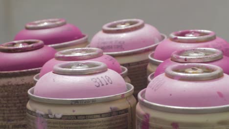 grupo de latas de pintura en aerosol rosas vacías usadas