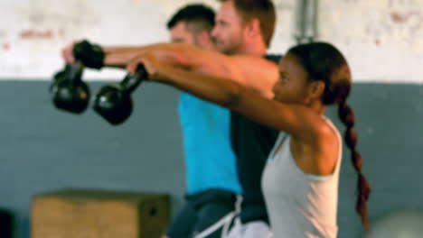 fit people lifting kettlebells in gym