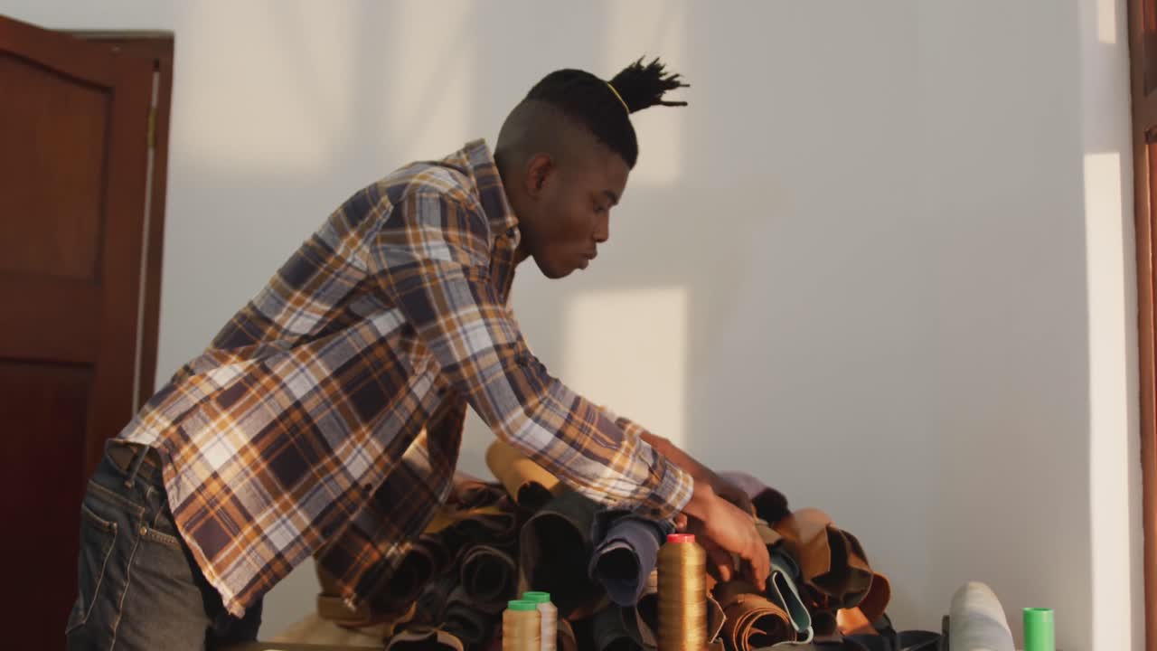 African american man searching for material in leather workshop