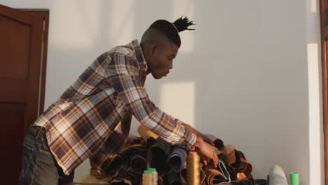 african american man searching for material in leather workshop