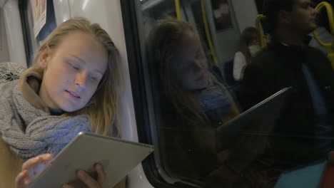 woman with tablet staying in touch in metro train