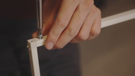 driving a screw into a diy frame using a screwdriver closeup shot