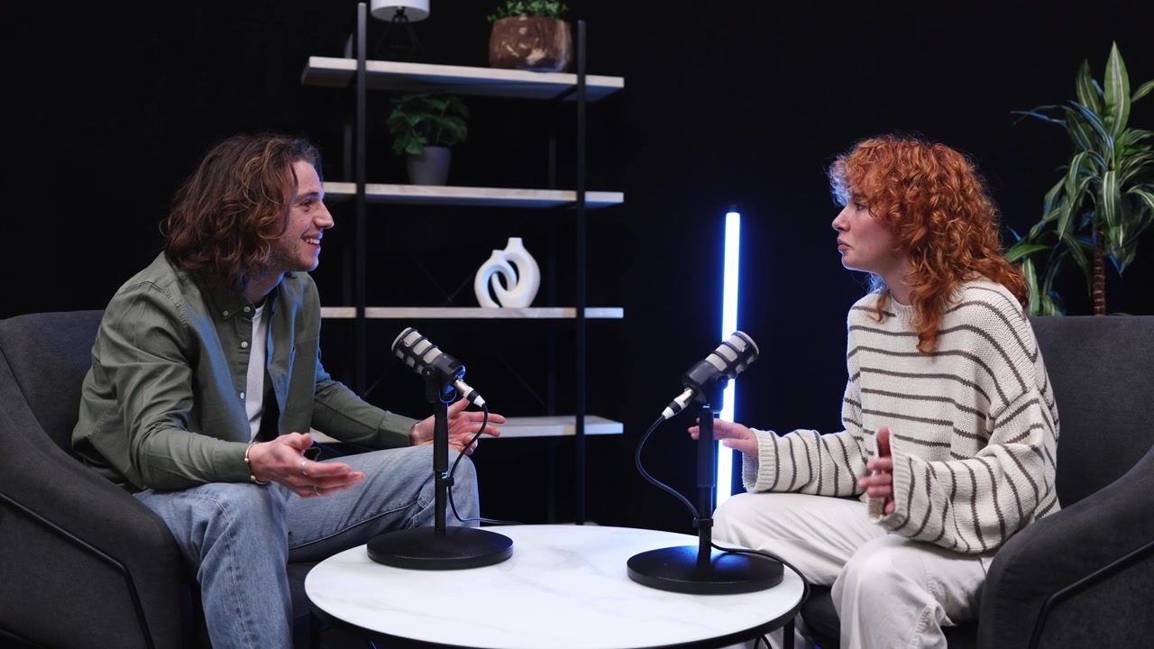 Young Man and Woman Recording a Podcast Interview in a Modern Studio